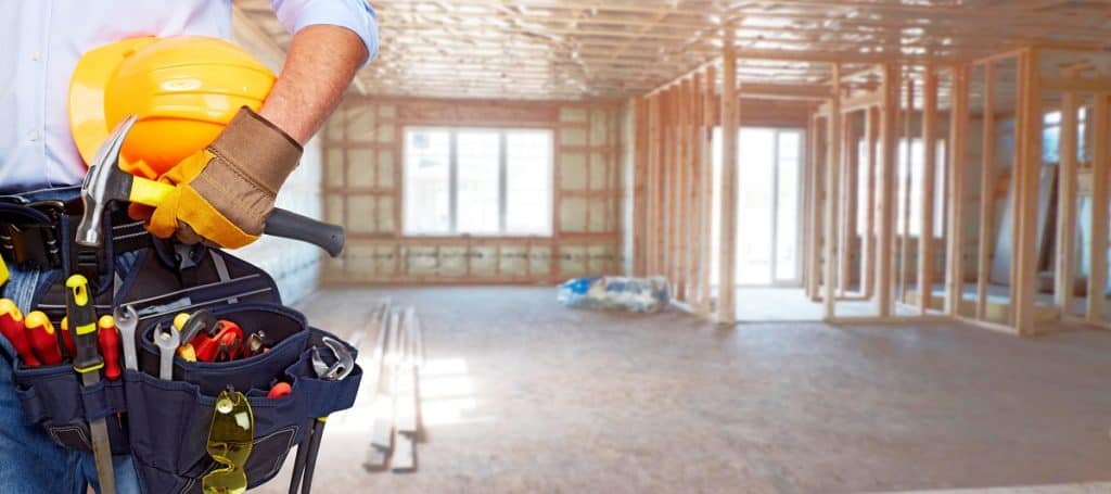 Carpenter with carpentry tools building a new home.